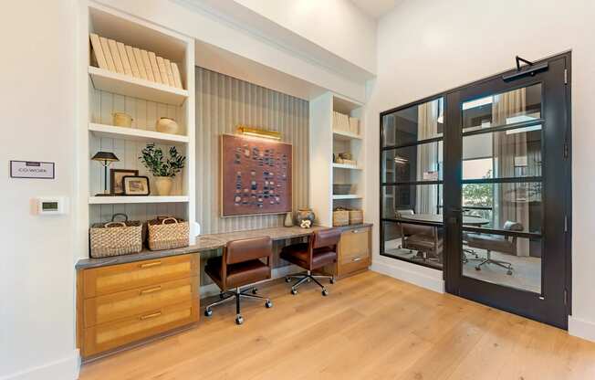 A room with a desk, chairs, and shelves with various items.