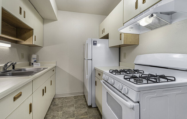 Galley kitchen with a stove and refrigerator and a sink