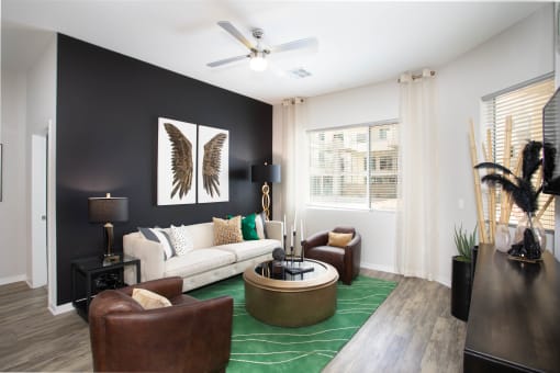 a living room with a white couch and a green rug