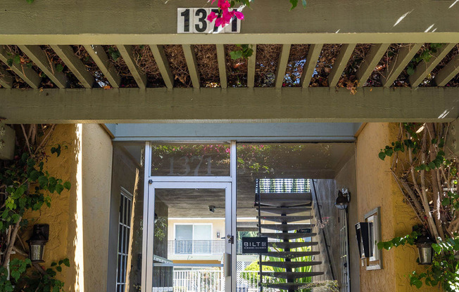 the front door of a building with potted flowers on top of it