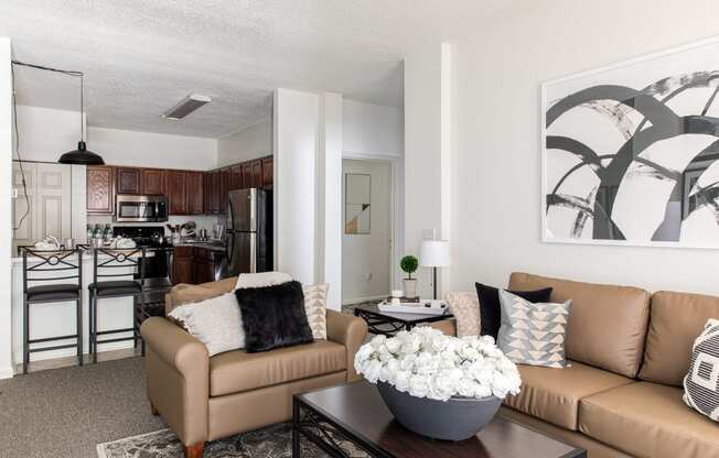 a living room with a couch and a chair and a table with a vase of flowers