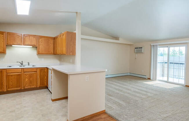 Kitchen with Open Concept Living Area with A/C Unit and Balcony