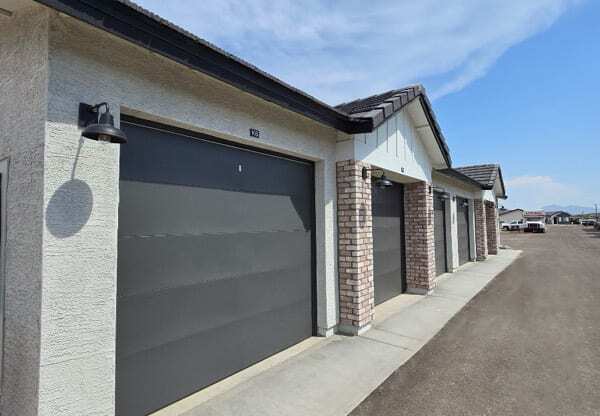 the front of a building with a gray garage door