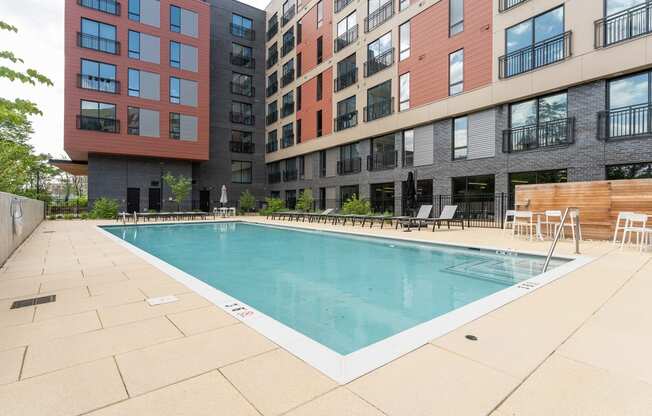 a swimming pool with chairs and umbrellas in front of a building at Hydro, Virginia, 23224