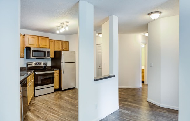 a renovated kitchen with wood flooring and stainless steel appliances