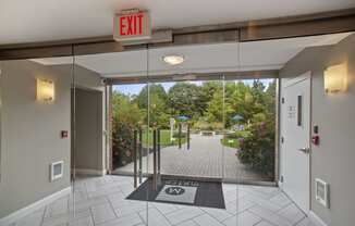 a door leading to a courtyard with a gate and a exit sign