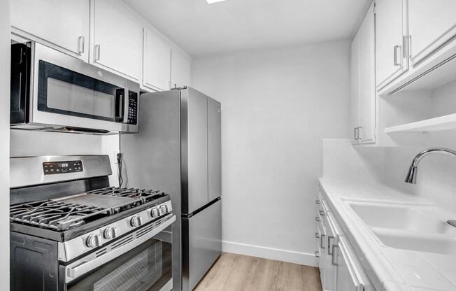 a kitchen with stainless steel appliances and white cabinets