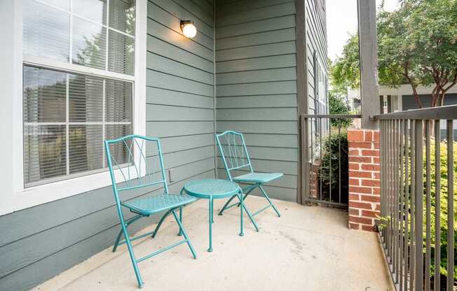A blue chair and table set on a porch.