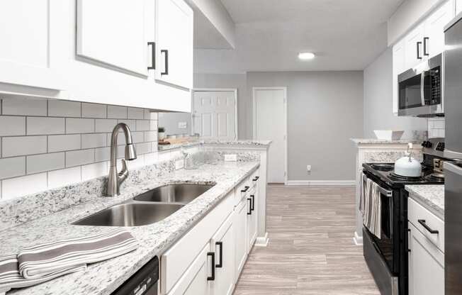 a kitchen with white cabinets and granite counter tops and a sink