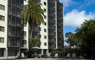 A tall building with a pool in front of it at Hampton Apartments in Clearwater, FL 33759