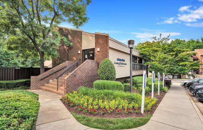 a brick building with a staircase and landscaping in front of it