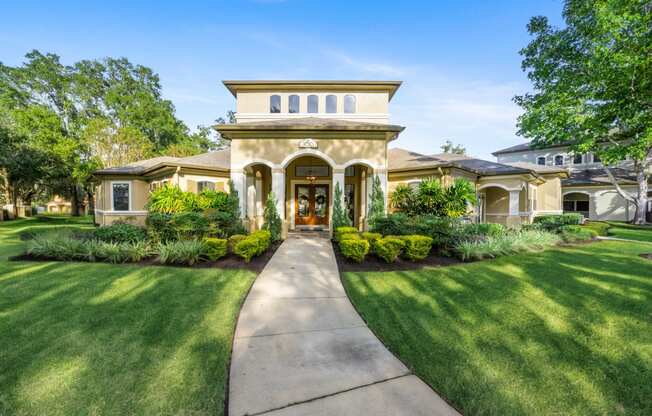 a house with a walkway and lawn in front of it