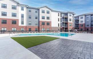 A large apartment complex with a pool in the courtyard.