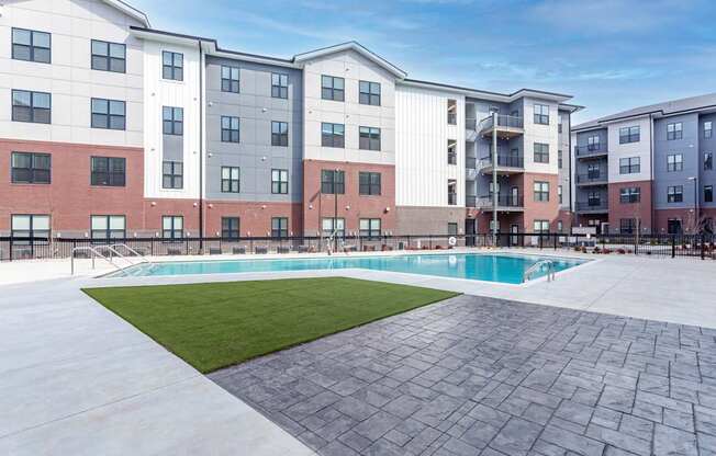 A large apartment complex with a pool in the courtyard.