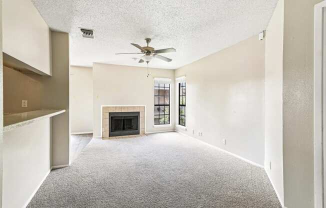 Living room with fireplace and carpet floor at Bandera Crossing apartments in San Antonio, TX