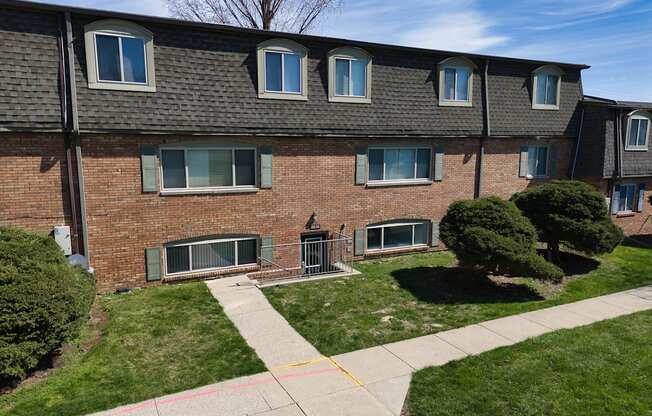 a brick house with a sidewalk in front of it