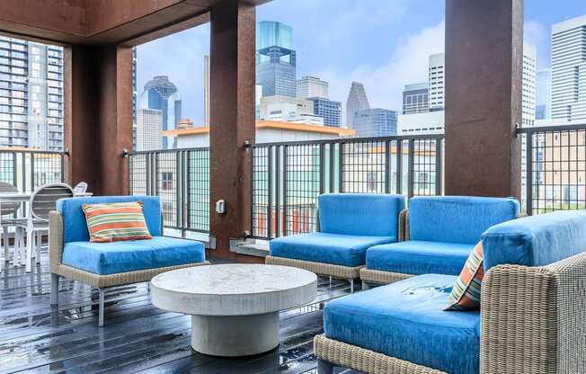 a lounge area with blue chairs and a view of the city