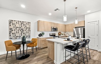 A kitchen with a white counter and black chairs.