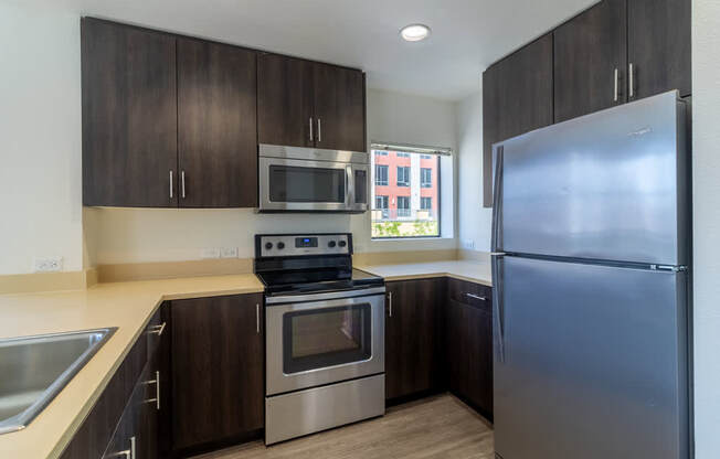 A kitchen with a stainless steel refrigerator, oven, and microwave.
