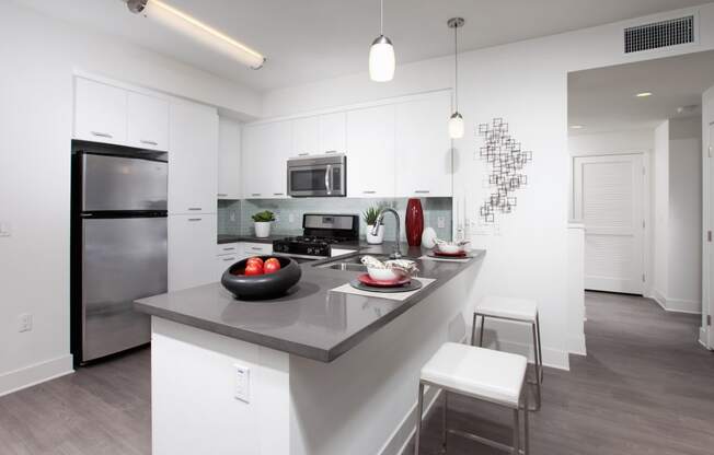 a kitchen with white cabinetry and an island with a gray countertop