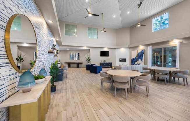 A spacious room with a round table and chairs, a mirror, and a television.