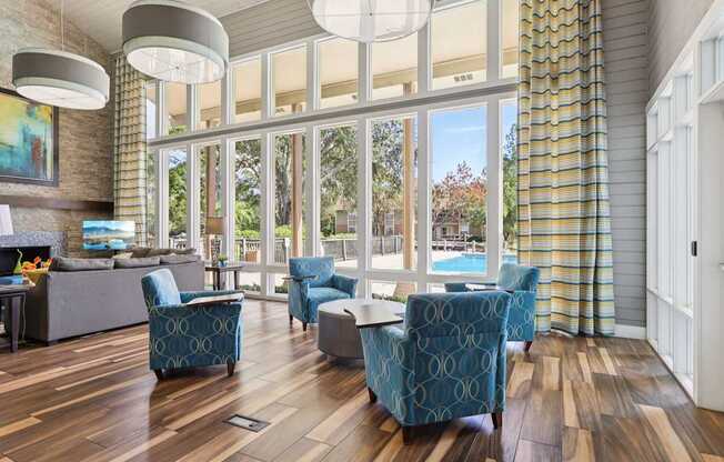 A living room with a pool outside the window.