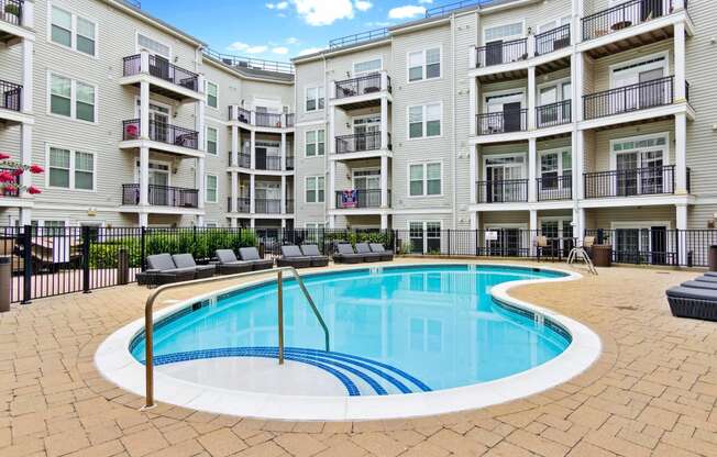 a swimming pool in front of an apartment building at Metro 303, Hempstead