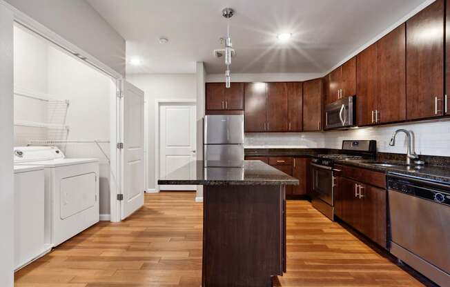 A kitchen with wooden floors and stainless steel appliances.