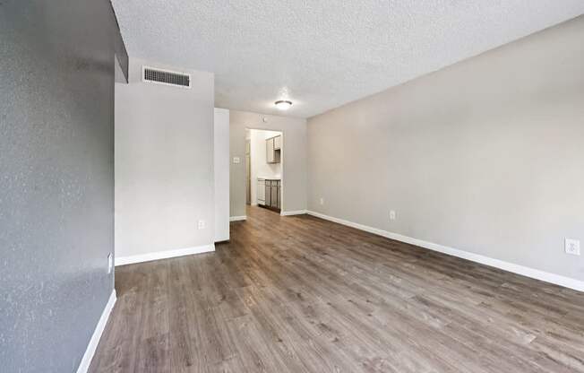 A room with wooden flooring and white walls.