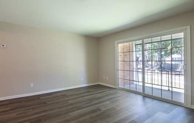 an empty living room with a door to a patio