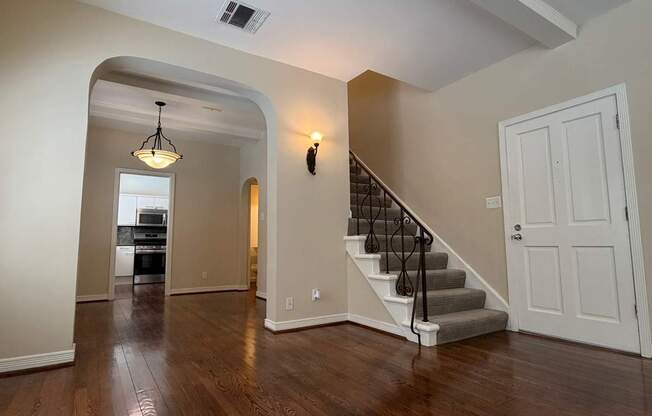 A spacious room with a staircase leading to the second floor.