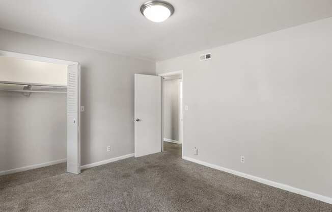 an empty living room with carpet and a closet