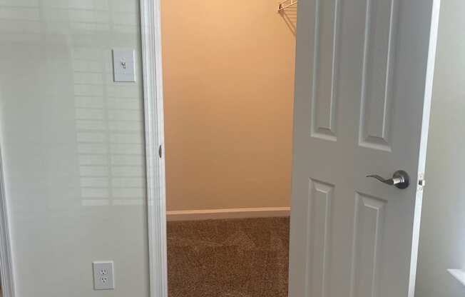 a room with a closet and a door open to a bathroom