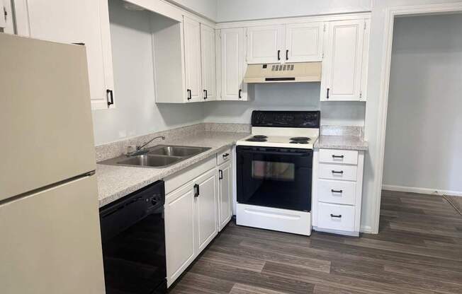 A kitchen with white cabinets and a black oven.