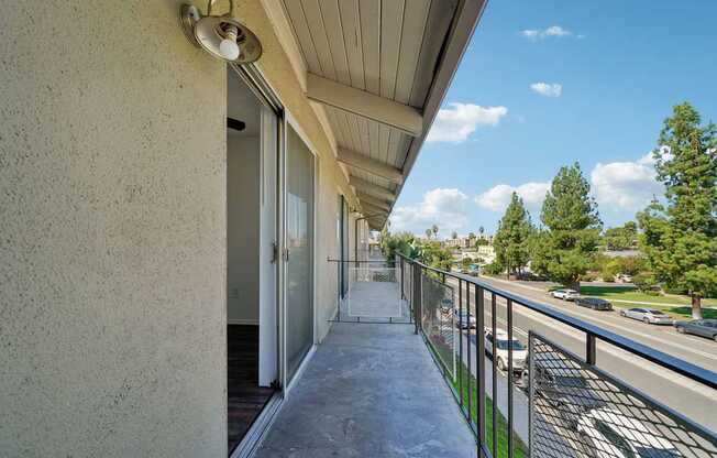 A balcony with a metal railing and a concrete floor.