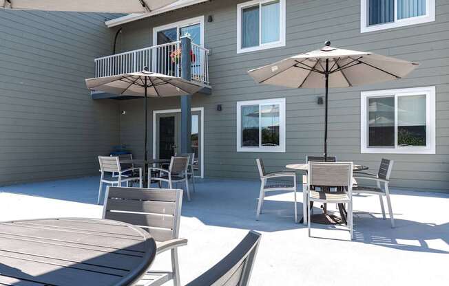 A patio with a table and chairs and an umbrella.