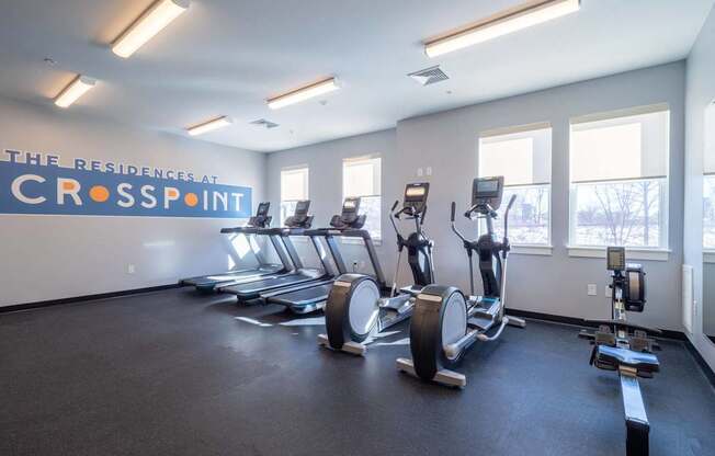 A cardio area in the fitness center equipped with treadmills and rowing machines.