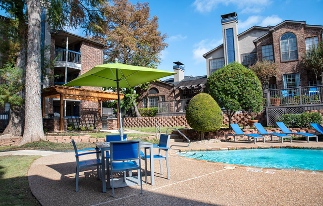 our apartments have a pool and patio with chairs and umbrella