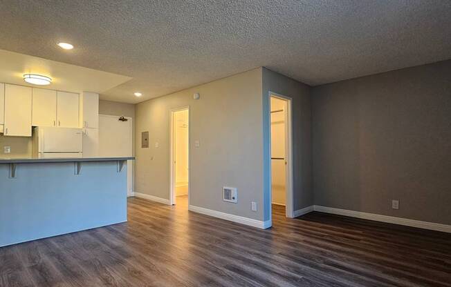 A spacious room with a kitchen area and a bar.