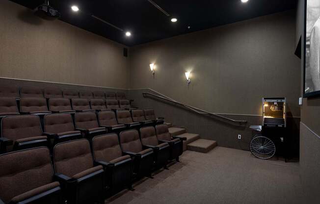 A movie theater with rows of seats and a projector.