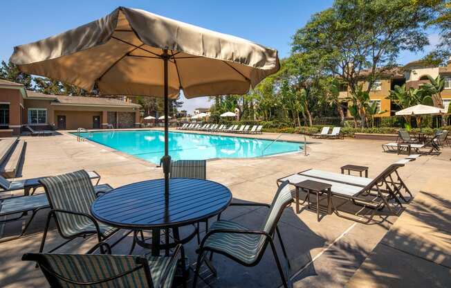 a swimming pool with tables and chairs and an umbrella