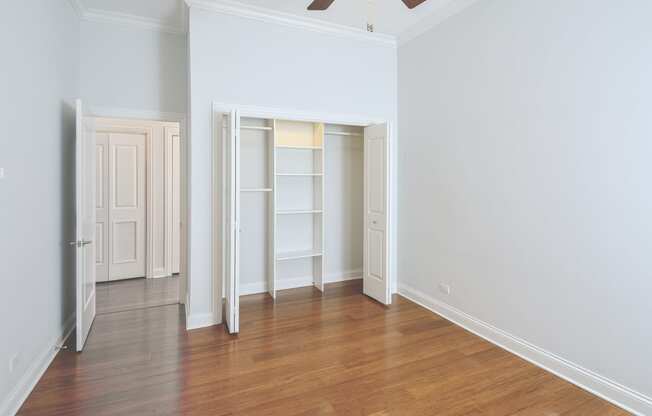 an empty living room with wood floors and a ceiling fan