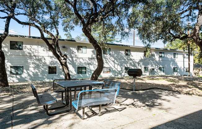 a patio with a table and chairs in front of a building