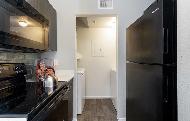 a kitchen with stainless steel appliances and a black refrigerator