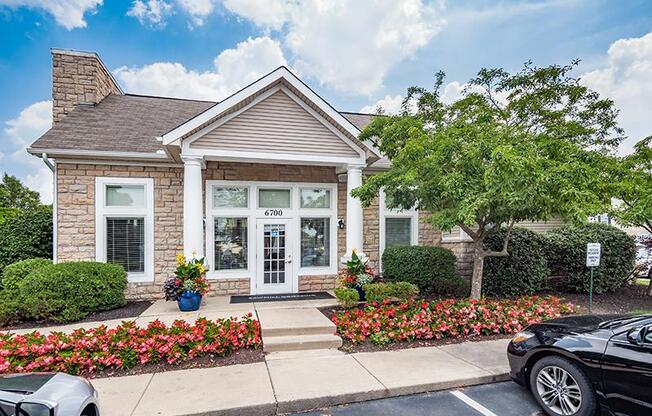 A small house with a black car parked in front.