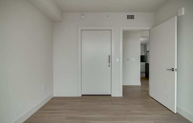 A white door is in a room with wood flooring.