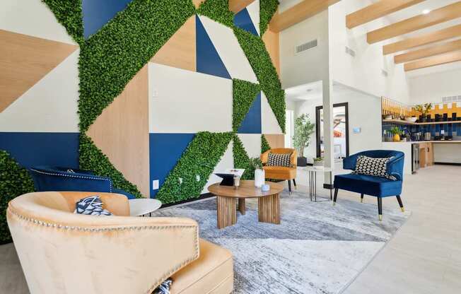 A living wall with a geometric pattern is behind a sofa and chairs.