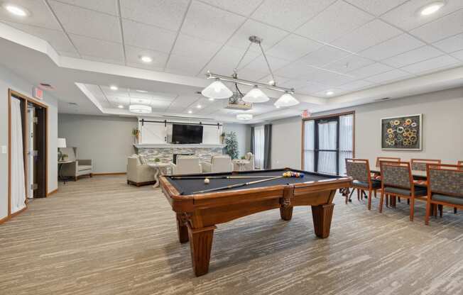 a community room with a pool table in the center