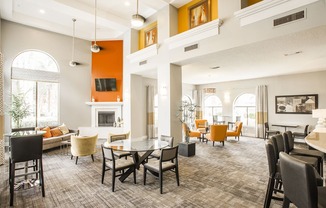 a large living room with tables and chairs and a fireplace