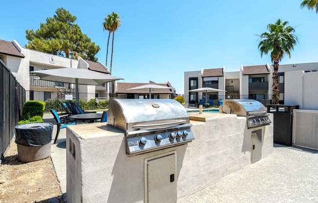 A large outdoor grill is in the foreground of a residential area.